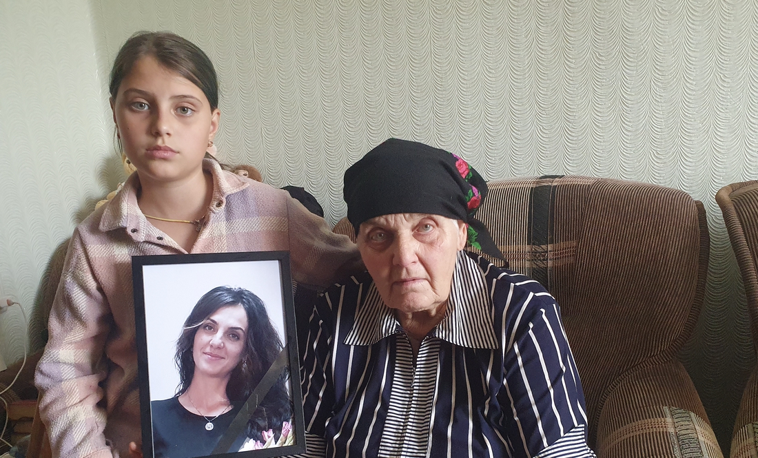 Поліна Коновал з бабусею Вірою Пилипівною. У руках тримає портрет загиблої матері Юлії Коновал
