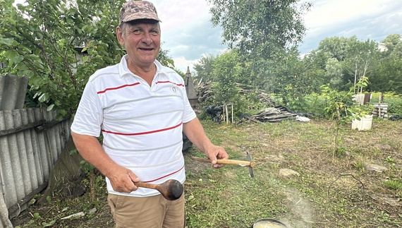 Сергій Рудько тримає в лівій руці "баранчика". Варить козацьку кашу