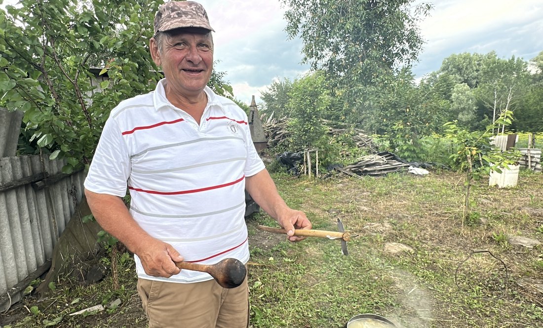 Сергій Рудько тримає в лівій руці "баранчика". Варить козацьку кашу
