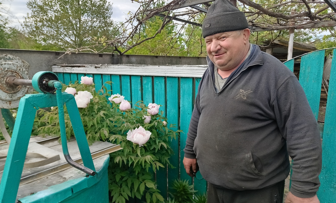 Володимир Ловейко біля піонового дерева у своєму дворі
