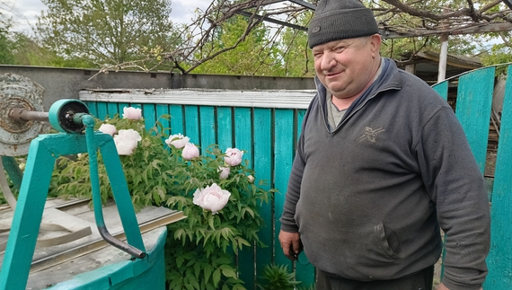 Володимир Ловейко біля піонового дерева у своєму дворі