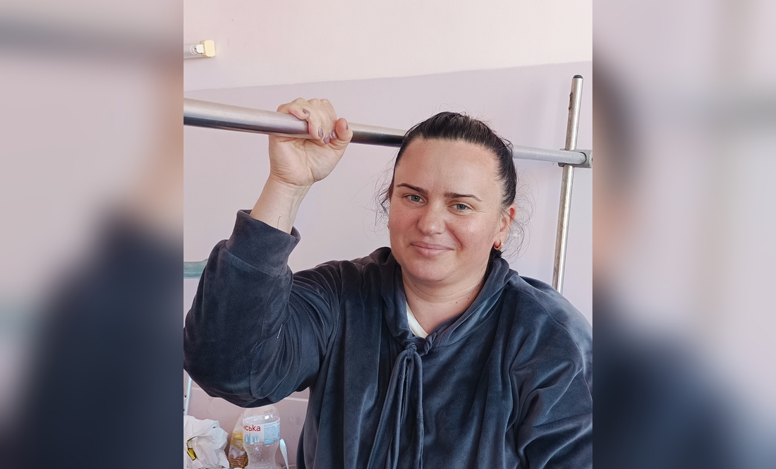Алла Кузьменко тримається за поручень спеціального ліжка в хуріргічному відділенні