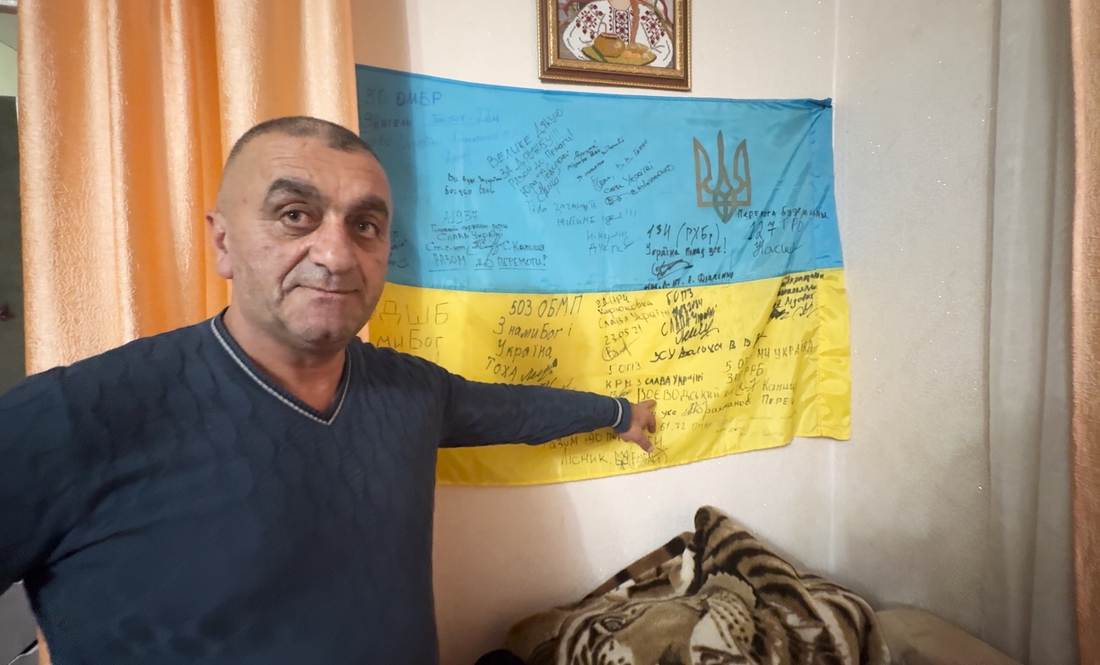 Аріф Асланов біля свого бойового прапора