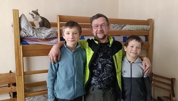 Олександр Рибенок з синами Нікітою (зліва) та Віктором (справа). Позаду двоярусне ліжко хлопців і кіт Мурчик
