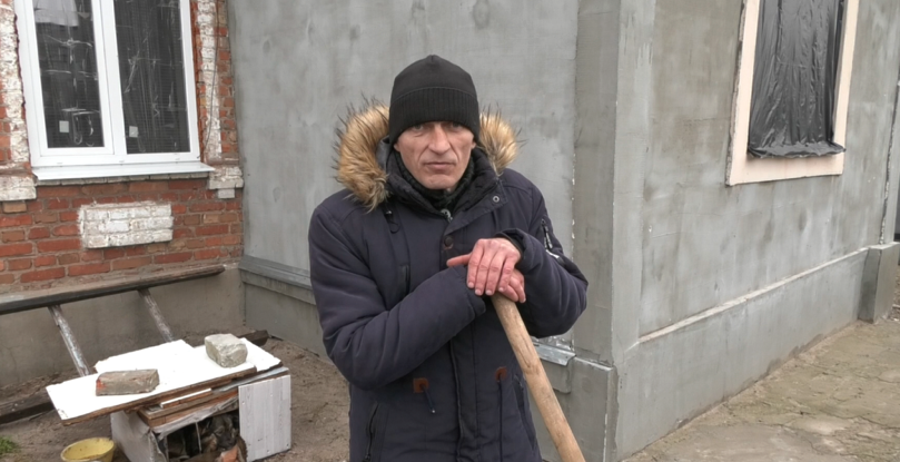 Олександр Коцюба працює біля власного будинку, який постраждав від російських обстрілів