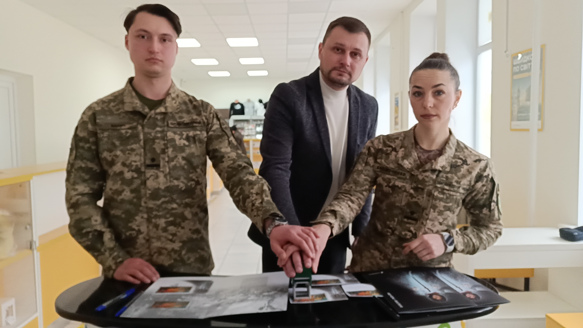 Зліва направо: Олександр Бабич, Ігор Ярош та Світлана Халімоненко гасять марку