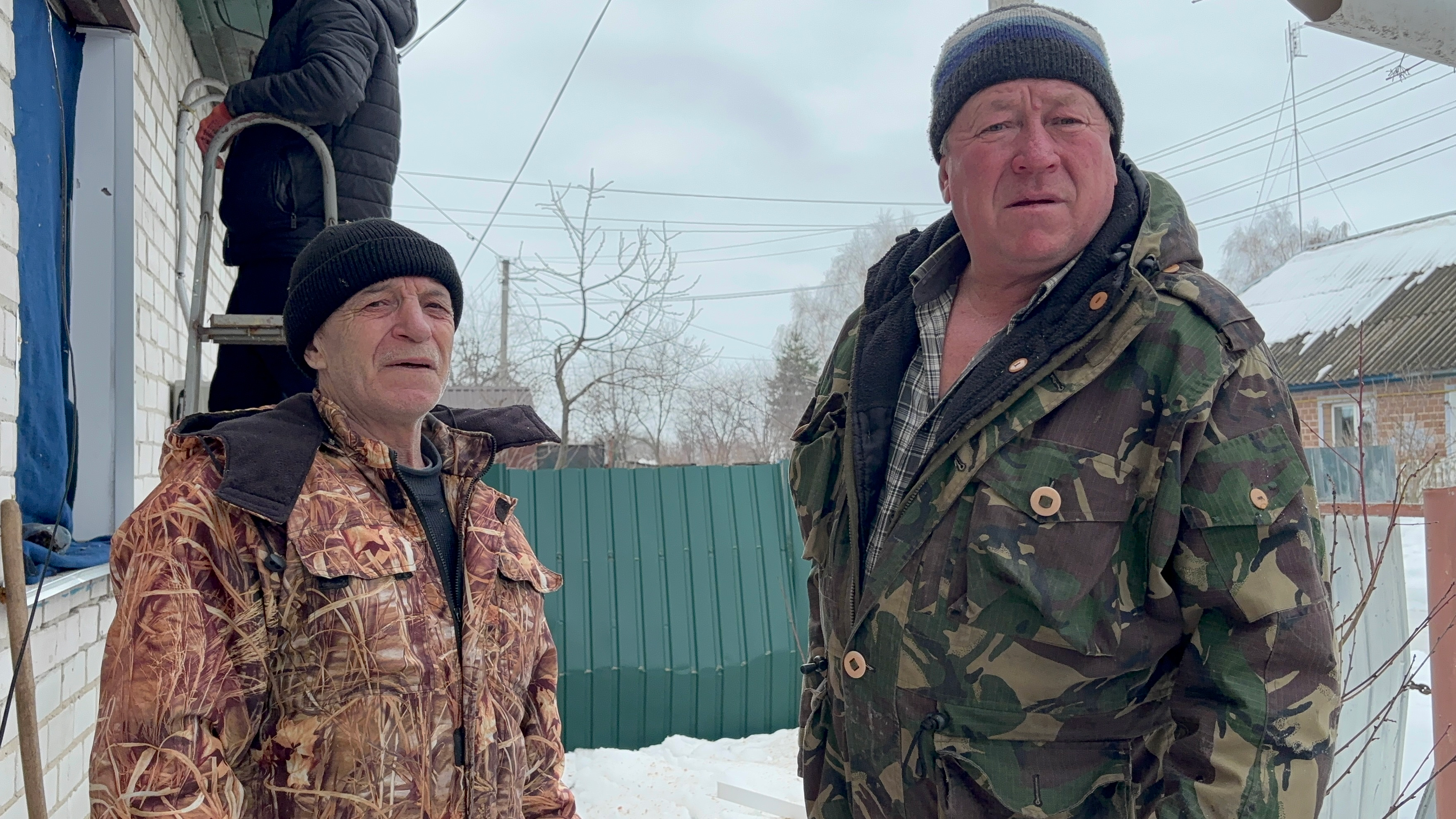 Зліва направо: меняни Іван Петренко та Микола Ігнатенко латають вікна після атаки шахеда